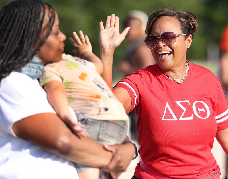 Treveda Shah, from DeKalb, (right) gets a high-five from Legend Chappel, 2, from DeKalb, Friday, July 18, 2025, during the DeKalb Peace Walk and Rally. The event, which featured a march, food vendors and music, was held to encourage the community to work together against gun violence.