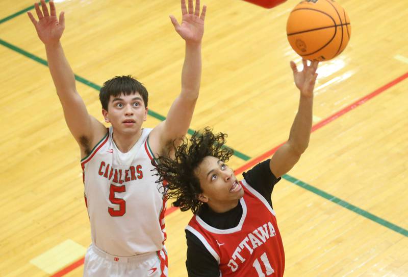 Ottawa's Hezekiah Joachim does a reverse layup over L-P's Erick Sotelo on Friday, Feb. 7, 2025 in Sellett Gymnasium at L-P High School.