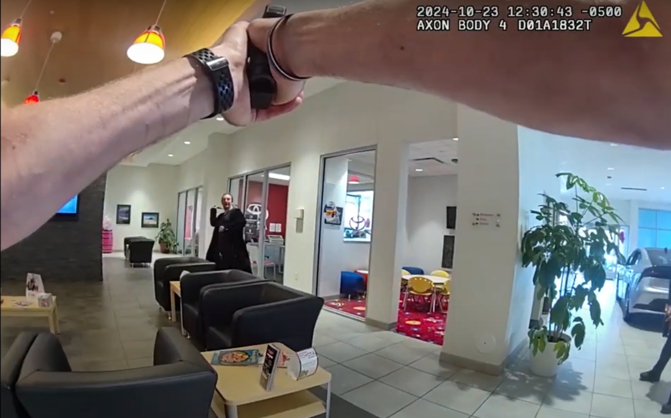 Body camera footage of DeKalb Police Officer Brian Bollow shows Charles M. Tripicchio (left) throw a knife at Bollow, who points a gun, during an Oct. 23, 2024, attack at Brian Bemis Toyota of DeKalb, 1890 Sycamore Road. Bollow and Police Chief David Byrd shot Tripicchio, who survived, when he refused orders to put the weapons down. (Screenshot of footage provided by Illinois State Police)