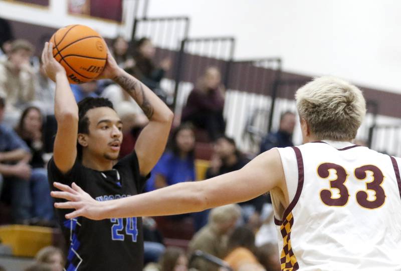 Woodstock's JJ Stokes looks to pass as hie is guarded by Richmond-Burton's Luke Robinson during a Kishwaukee River Conference boys basketball game on Friay Jan. 9  2026, at Richmond-Burton High School, in Richmond.