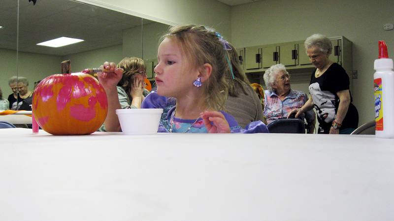 Madisyn Morgan, 3, of Genoa paints a pumpkin at the Grand Victorian Halloween Boo Bash on Oct. 17. A number of families of residents came to the party at the retirement home.