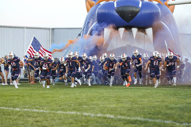 Oswego runs out onto the field before football game between Bolingbrook at Oswego Friday, Sept 12, 2025  in Oswego.