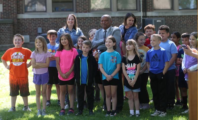 Lincoln Elementary students and Illinois Transportation Secretary Omer Osman pose for a photo outside of Lincoln Elementary School on Thursday, May 30, 2024 in Mendota. Illinois Transportation awarded Mendota for new sidewalks that help students more opportunities to walk, bike and roll as part of the Safe Routes to School Program.