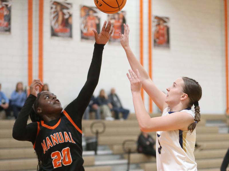Marquette's Chloe Larson pulls up in the lane to shoot a shot over Manual's Breyasia Grayson during the Falcon-Irish Thanksgiving Tournament on Monday, Nov. 18, 2024 at Flanagan High School.