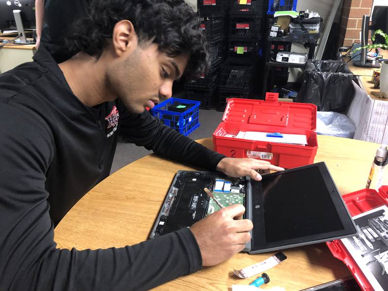 Huntley High School senior Varshan Suhirtharen removes Chromebook parts at Huntley High School Dec. 11, 2023. Suhirtharen participates in the school's help desk program