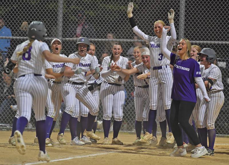Downers Grove North’s Jenna Gordon arrives at home plate to meet jubilant teammates after hitting a walk off home run ending a game against Downers Grove South on May 14, 2026 at McCollum Park in Downers Grove.