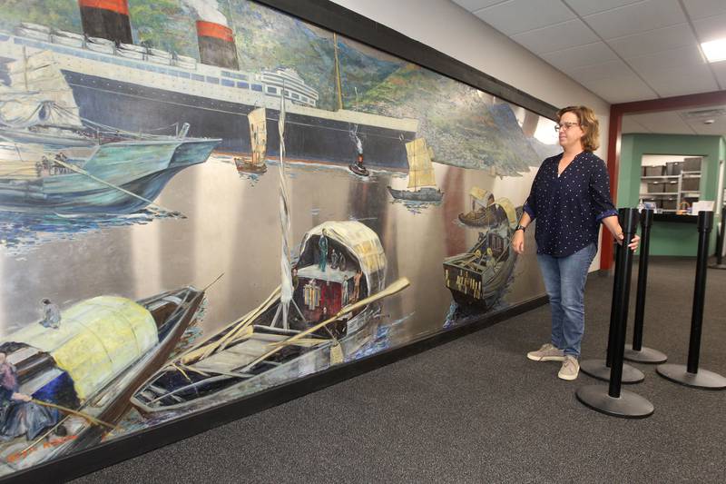 Candace H. Johnson for Shaw Local News Network
Amy Whitis, interim Parks & Recreation manager, looks at the Buell Mullen mural on display close to her office at the Lakefront Park building in Fox Lake.The mural titled, "Hong Kong," features a view of the Hong Kong harbor and is on loan from the National Museum of the American Sailor. It is approximately 20 ft. long and six-feet high on stainless steel and weighs about 600 pounds. This is one of a two pieces in a mural set with the other piece on display at the County Building in downtown Waukegan. (10/31/22)