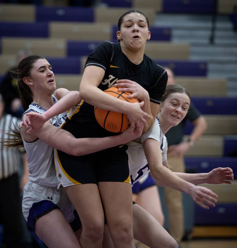 Herscher's Leia Haubner, center, pulls in a rebound over Wilmington's Sami Liaromatis, left, and Keeley Walsh, right, in a game on Thursday, January 29, 2026.