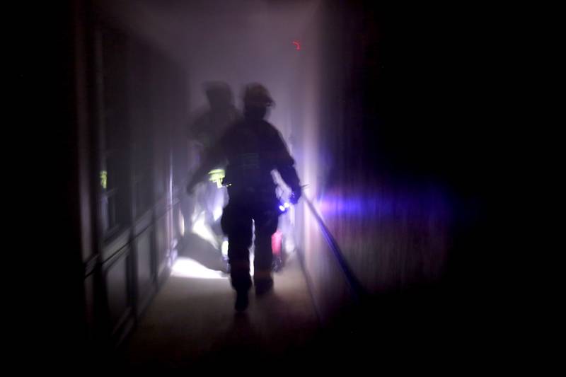 McHenry firefighters from RIT team two prepare to enter a smoke filled basement as they search for an injured firefighter on Tuesday April 15, 2025, during a RIT crew and chief divisional drill with other firefighters from area departments in a former bank building in Downtown McHenry.