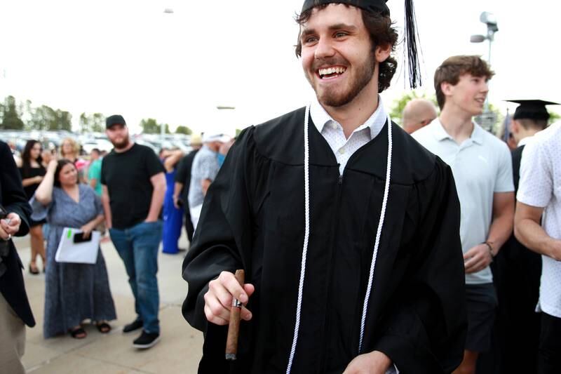 Kaneland High School graduate Davis Muiznieks enjoys a cigar following the school’s 2024 Commencement Ceremony at Northern Illinois University in DeKalb on Sunday, May 19, 2024.