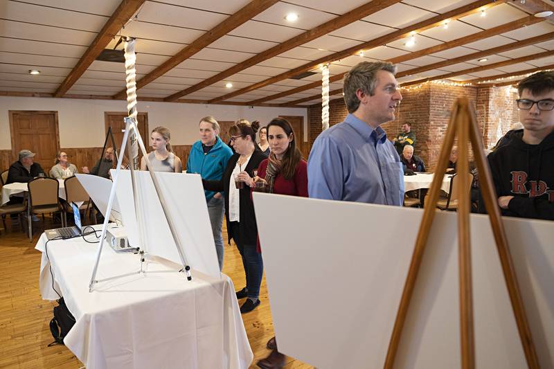 Members of the public look over artist renderings of the proposed $300-million-plus Sterling Riverfront Reimagined Project during a public event Wednesday, April 5, 2023. Plans call for worker apartments, a hotel and events center, and a rooftop bar/restaurant for the four buildings at the Lawrence site, which will be developed first.