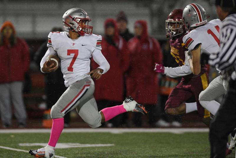 Palatine’s Dominick Ball runs for a touchdown as Schaumburg’s Takumi Fred chases him in a football game in Schaumburg on Friday, October 14, 2022.