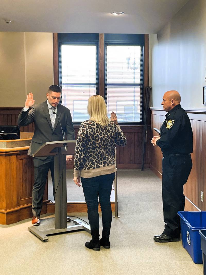 Devin Lang is sworn in as Ottawa's news police officer Friday, Jan. 5, 2023, by City Clerk Shelly Munks as Police Chief Brent Roalson watches.