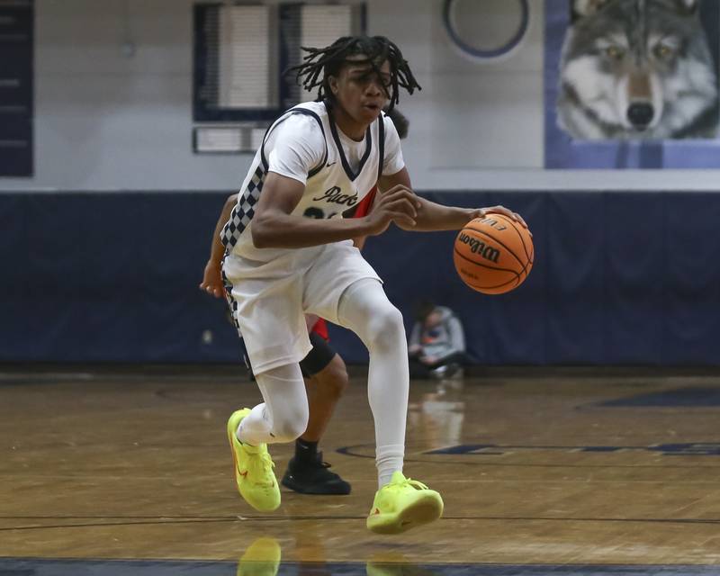 Oswego East's Mason Lockett (23) makes a move at the top of the key during their basketball game between Bolingbrook at Oswego East Friday, Jan 30, 2026 in Oswego.