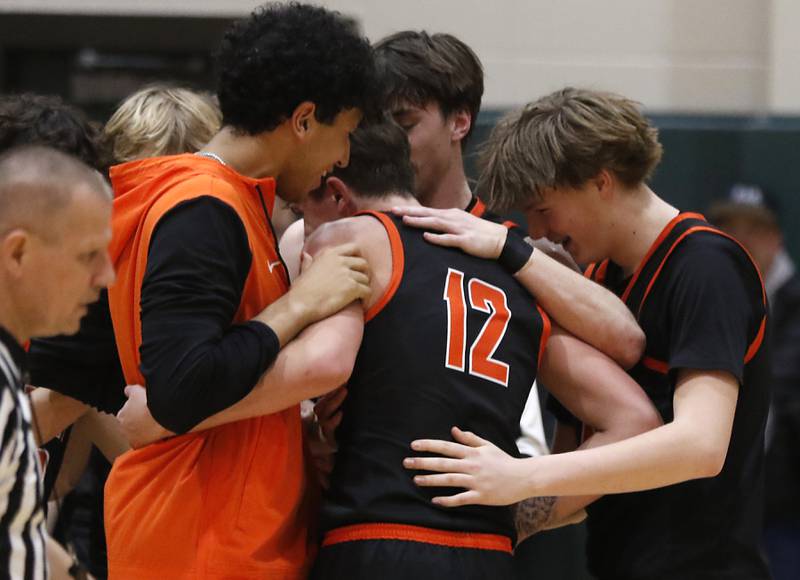 McHenry's Caleb Jett is hugged by his teammates after he score his 1,000 career point during a Fox Valley Conference basketball game against Crystal Lake South on Friday, Jan. 31, 2025, at Crystal Lake South High School.