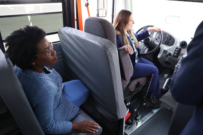 State Senator Rachel Ventura, D-43, gets instructions to drive an electric bus as U.S. Representative Lauren Underwood, D-14, sits behind her at the Lion Electric manufacturing facility on Friday, July 21st, 2023 in Joliet.