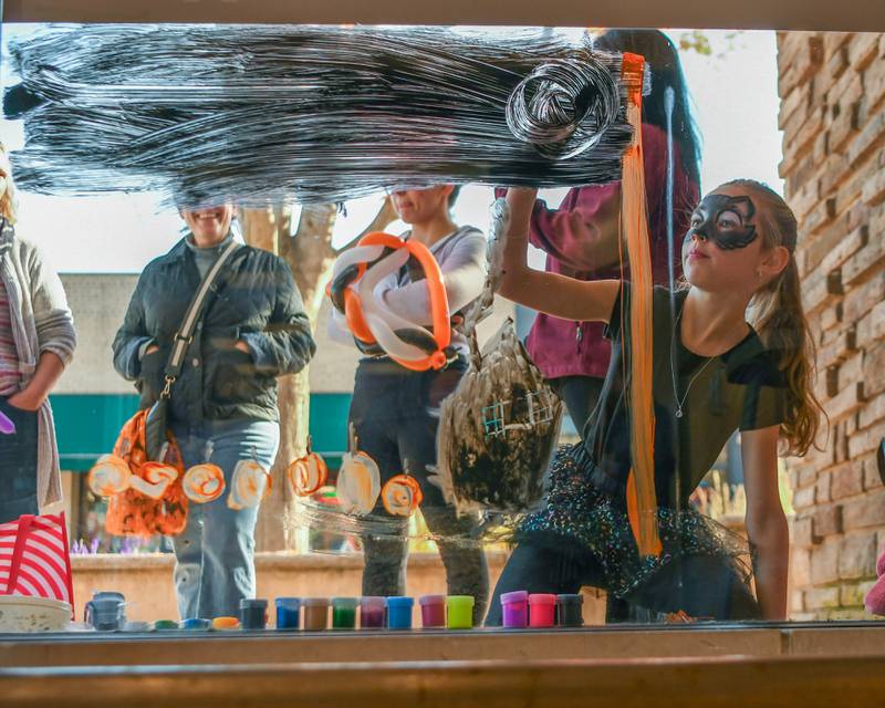 Aubrey K., 9 years old, of Downers Grove paints a portion of a window during the Halloween Window painting event held on Saturday Oct. 21, 2023, in downtown Downers Grove.