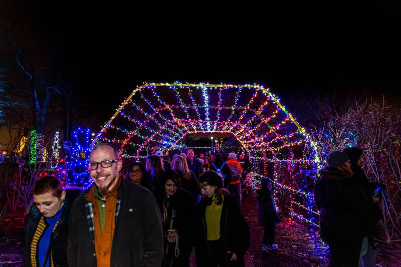 Visitors pass through a lighted arch at the Lombard Jingle Bell Jubilee. Dec 2, 2023