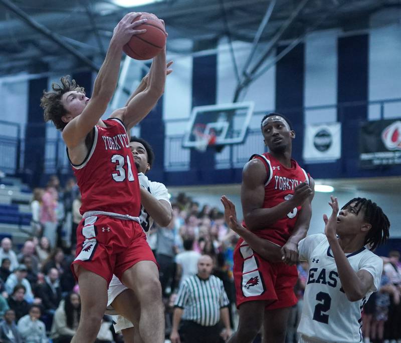 Yorkville's Bryce Salek (30) rebounds the ball against Oswego East during a basketball game at Oswego East High School on Friday, Dec 8, 2023.
