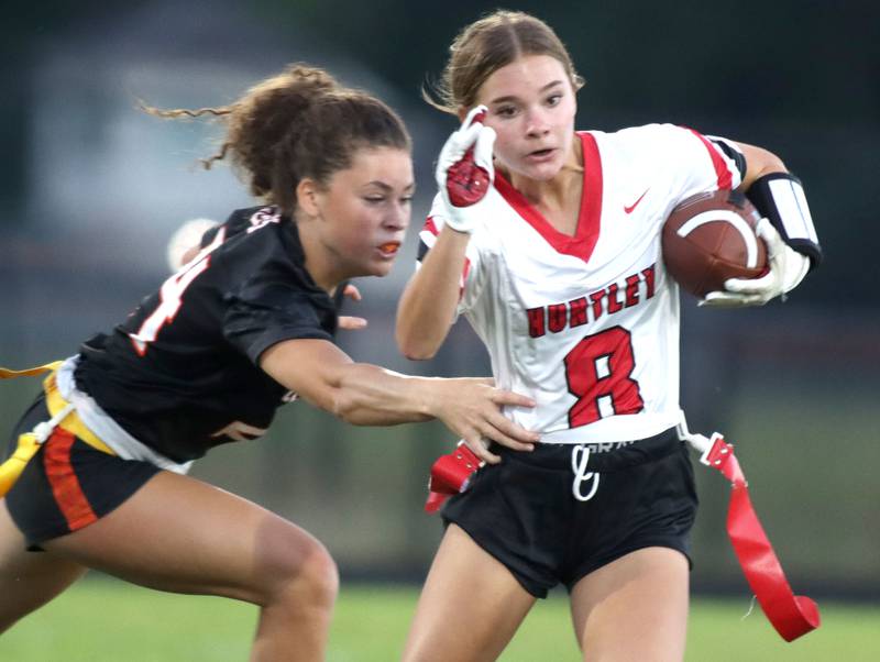 Huntley’s Addison Avi, right, runs the ball as Crystal Lake Central’s Elynor Raithel looks to grab Avi’s flag in varsity flag football at Owen Metcalf Field on the campus of Crystal Lake Central High School in Crystal Lake on Tuesday, Sept. 16, 2025.