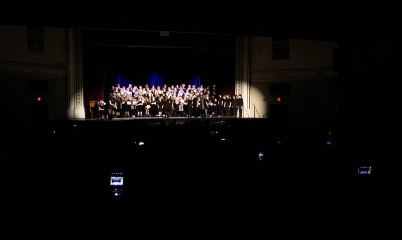 The flare of cell phone cameras record a performance of the 140-member combined choir at Dixon Public Schools' Choir Fest on Friday, March 3, 2023, at Wiltz Auditorium. The crowd was about 600, filling most of the lower section of the auditorium.