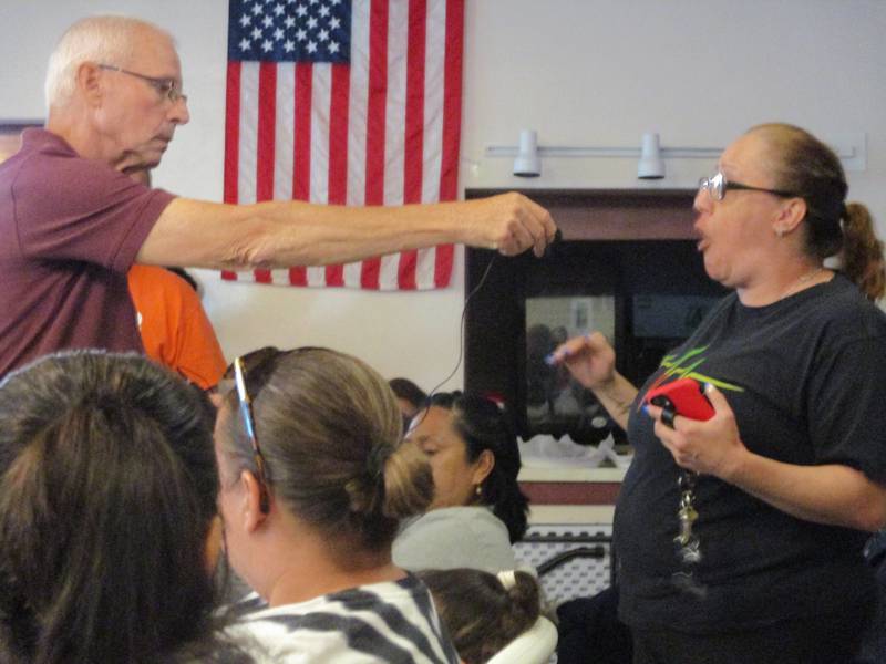Cunningham Neighborhood Council President John Sheridan provides a microphone for Julie Williams who said she will be afraid to let her grandchildren outside during the meeting about an apartment house for registered sex offenders in Joliet on June 1, 2022.