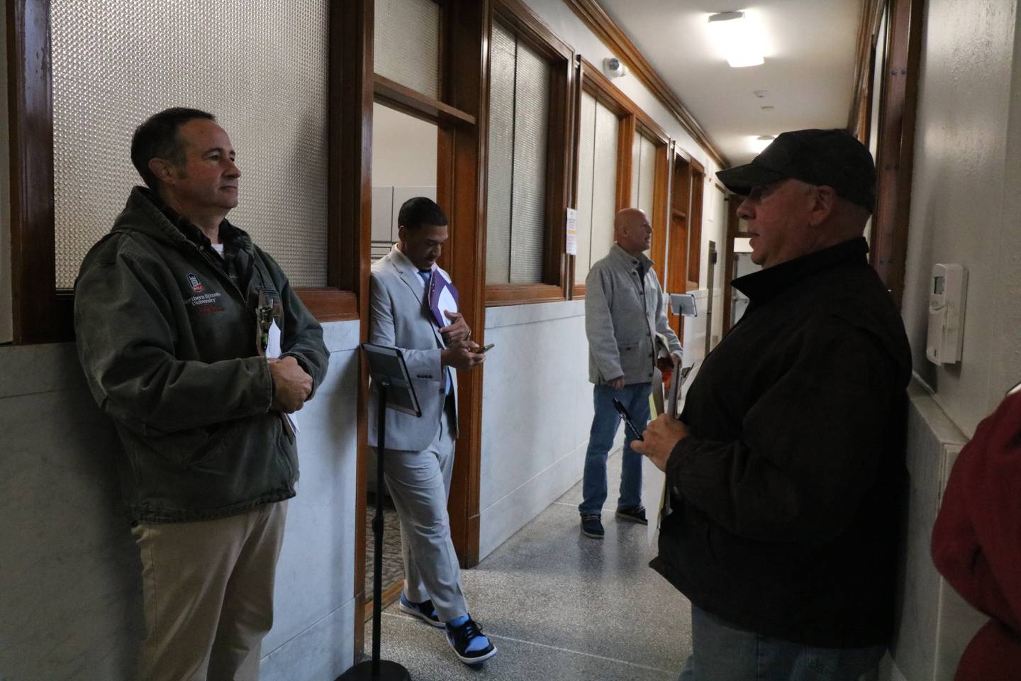 A group of people gather in line a hallway as they prepare to file nomination papers Nov. 12, 2024, at DeKalb City Hall.