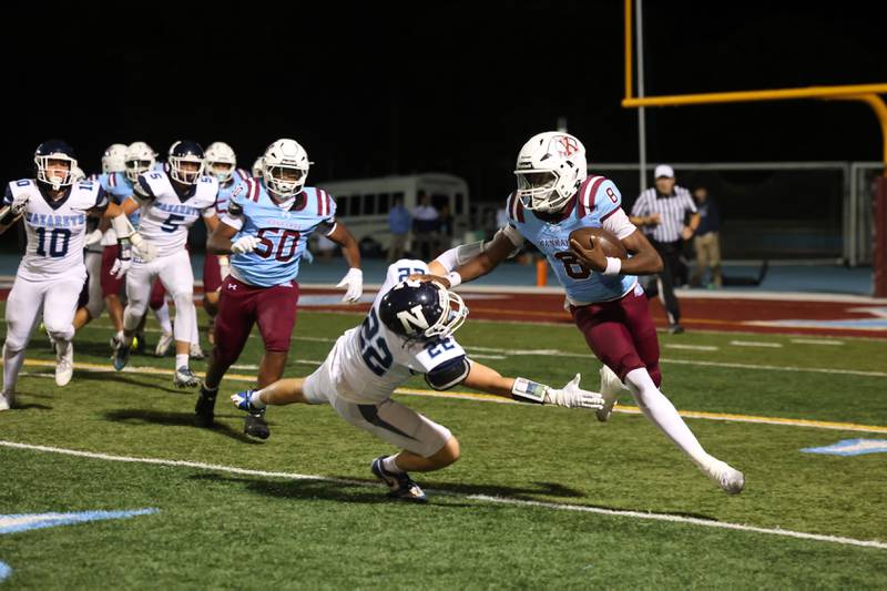Kankakee's Kymani Billings deflects a tackle by Nazareth's Emmett Hartnett during Kankakee's 33-12 loss to Nazareth on Friday, Aug. 29, 2025.