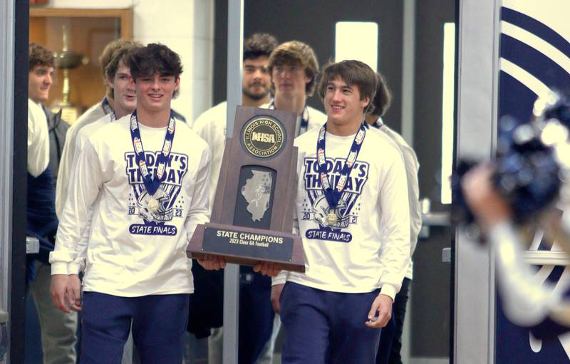 Players march into the main gym during a celebration of the IHSA Class 6A champion Cary-Grove football team at the high school Sunday.