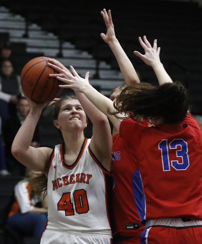 McHenry's Erin Nothdorf shoots the ball as she is guarded by Monica Sierzputowski (center) and Sara Farrell during a Fox Valley Conference girls basketball game on Tuesday, Dec. 12, 2023, at McHenry High School.