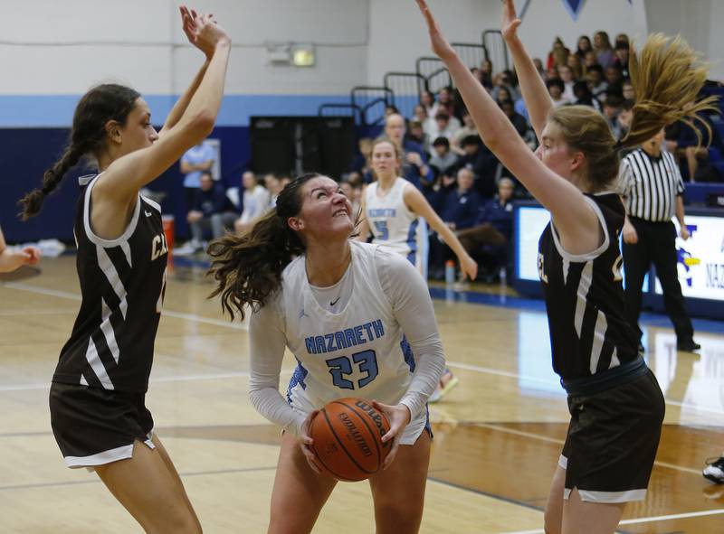Nazareth's Danielle Scully (23) starts to put up a shot during the girls varsity basketball game between Carmel High School and Nazareth Academy on Wednesday, Dec. 7, 2022 in LaGrange, IL.