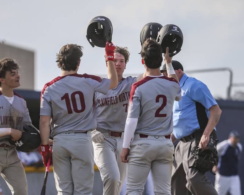 Plainfield North's Gavin Persson (7) is greeted at home after his home run during a baseball game between Plainfield North and Oswego East, Monday, April 28, 2025 in Oswego.