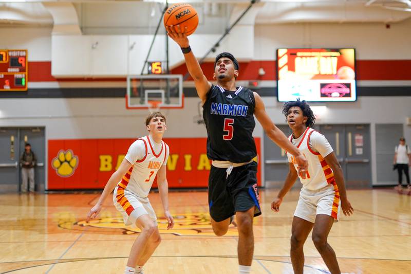 Marmion's Ali Muhammed Tharwani (5) drives to the hoop against Batavia's Evan Blankenship (3) and Xavier Justice (21) during a game at Batavia High School on Wednesday, Nov. 26, 2025.