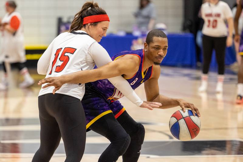 Devon “Livewire” Curry (8) of the Harlem Wizards dribbles around Mrs. Hogan (15) of Woodland High School on Wednesday, April 16, 2025 at Woodland High School in Streator.