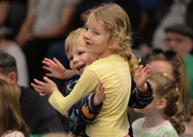 Tessa and Oliver Swanson of Downers Grove clap to the music while watching Trinity Irish Dancers perform at the Downers Grove Library Saturday, March 16, 2024.