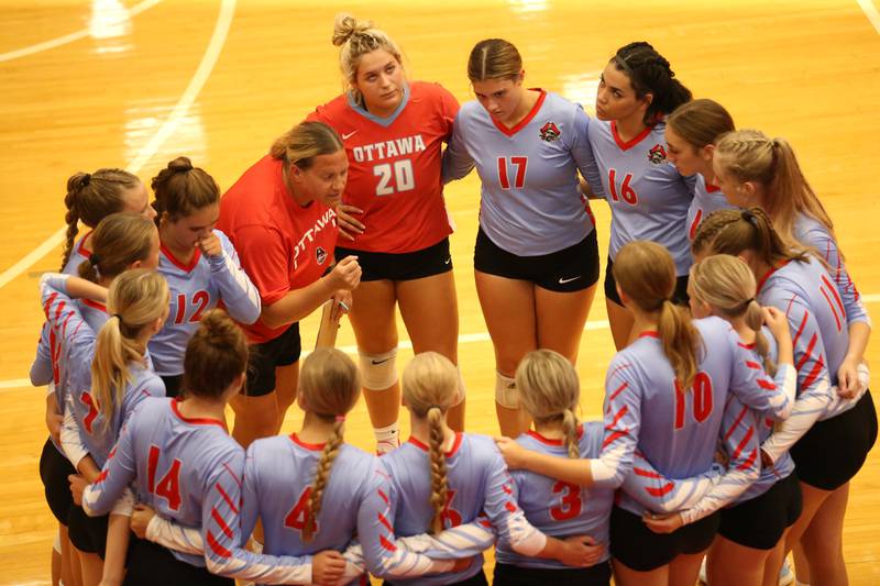 Ottawa volleyball head coach Jenn Crum (left) huddles with her team against Plano on Thursday, Aug. 31, 2023 in Kingman Gym at Ottawa High School.