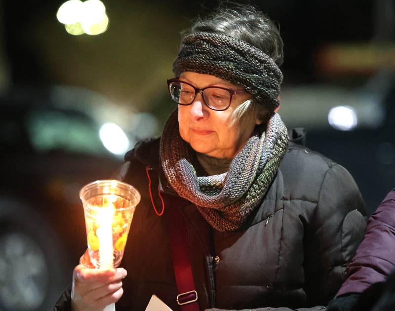 Jane School holds a candle Monday, Jan. 26, 2026, during a vigil outside the DeKalb County Legislative Center in Sycamore after second shooting death in Minnesota involving ICE officers.