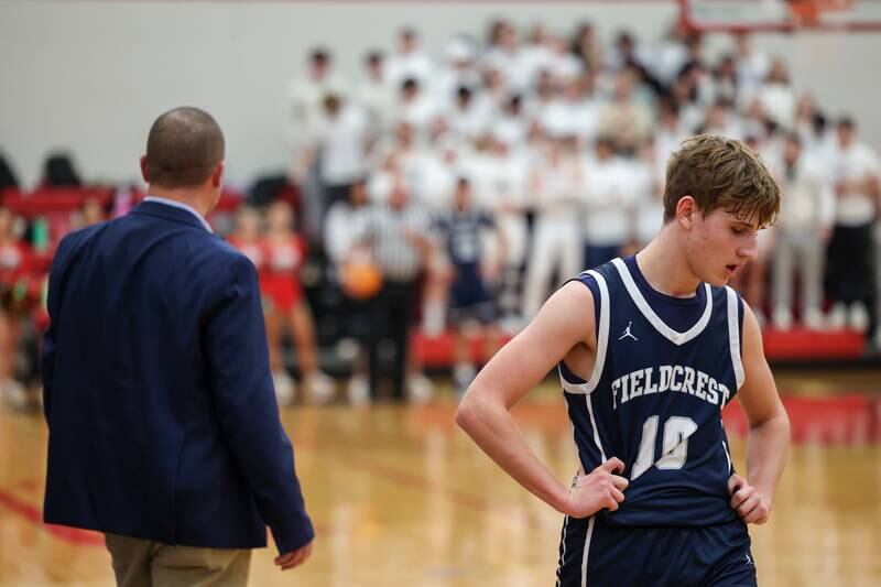 Kash Klendworth of Fieldcrest walks past coach Jeremy Hahn during game on Saturday, December 14, 2024 at Hall High School in Spring Valley.