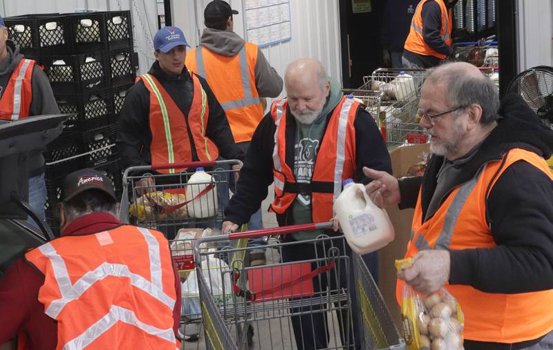 Volunteers prepare to load cart fulls of food into trunks during the Thanksgiving distribution on Wednesday, Nov. 19, 2025 at the Hall Township Food Pantry in Spring Valley. Nearly 500 families will receive food from this years distribution.