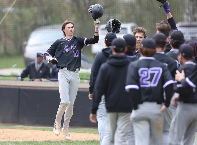 Downers Grove North's Jude Warwick (13) is congratulated by his teammates after his homerun during the varsity baseball game between Downers Grove South and Downers Grove North in Downers Grove on Saturday, April 29, 2023.