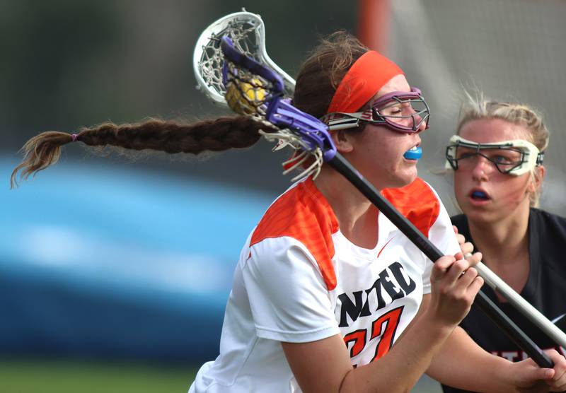 Crystal Lake co-op’s Anna Starr, front, moves past Huntley’s Katie Ferrara in varsity girls lacrosse on Friday, April 18, 2025, at Metcalf Field on the campus of Crystal Lake Central High School in Crystal Lake.