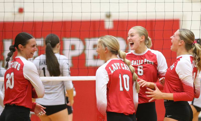 L-P volleyball players (from left) Anna Riva, Kelsey Frederick, Maggie Boudreau and Aubrey Duttlinger react after getting a point against Kaneland on Tuesday, Oct. 7, 2025 in Sellett Gymnasium at L-P High School.