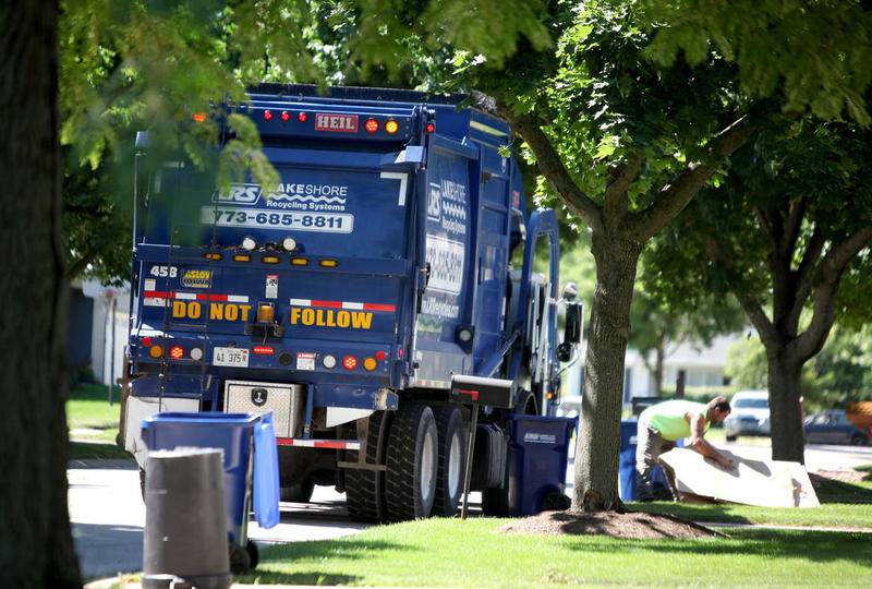 A Lakeshore Recycling Systems driver collects trash on Whittington Drive in Geneva on July 6 during the company's first week of service with the city.