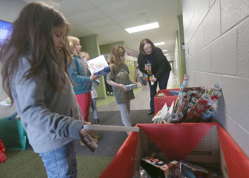 (From left) Dimmick students Onna Miller, Marie Austin and River Stallings place toys into bins with the help of Special Education instructor Kearsten Zielinski during the Small School Big Hearts campaign on Tuesday, Dec. 2, 2025 at Dimmick School in La Salle. The “Small School, Big Hearts” campaign is a toy drive organizded by third graders and celebrates the power of kindness, generosity and community spirit. Gifts will be wrapped and sent to Officer Santa with the La Salle Police Department and St. Jude. The school is accepting donations through Dec. 12.
