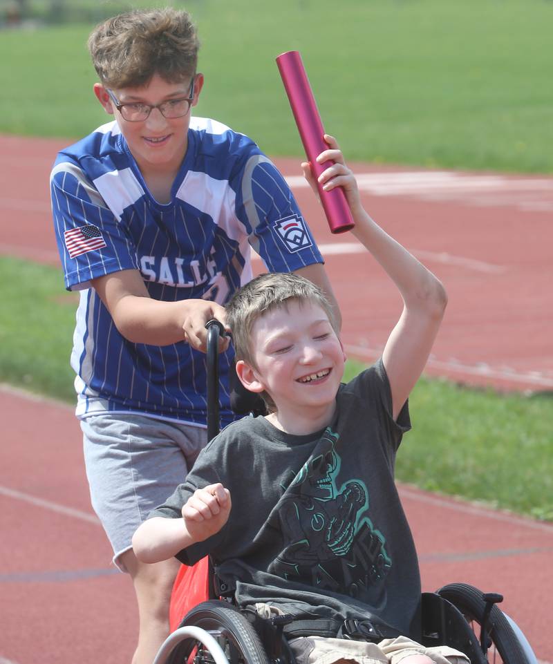 Lighted Way student Kobey is pushed by Trinity Catholic Academy eighth grader Jacob Frederick in the slalom during the Lighted Way and Trinity Catholic Academy PALS Spring Track Meet on Monday, May 13, 2024 at the L-P Athletic Complex in La Salle. Lighted way students participated in running, throwing, wheelchair slalom and much more.