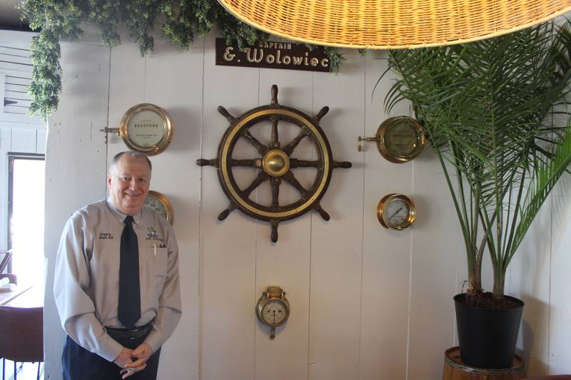 Port Edward Ziya Senturk stands next to a newly renovated wall decorated with late founder Edward Wolowiec's nautical artifacts.