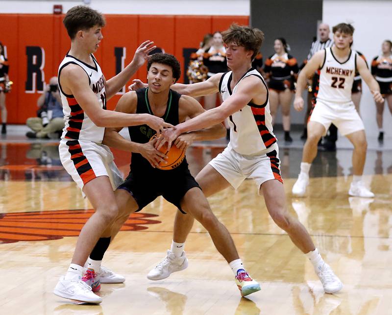 Crystal Lake South's Anthony Demirov is double teamed by McHenry's Caleb Jett (left)  and Dylan Hurckes during a Fox Valley Conference boys basketball game on Wednesday, Dec. 11, 2024, at McHenry High School.