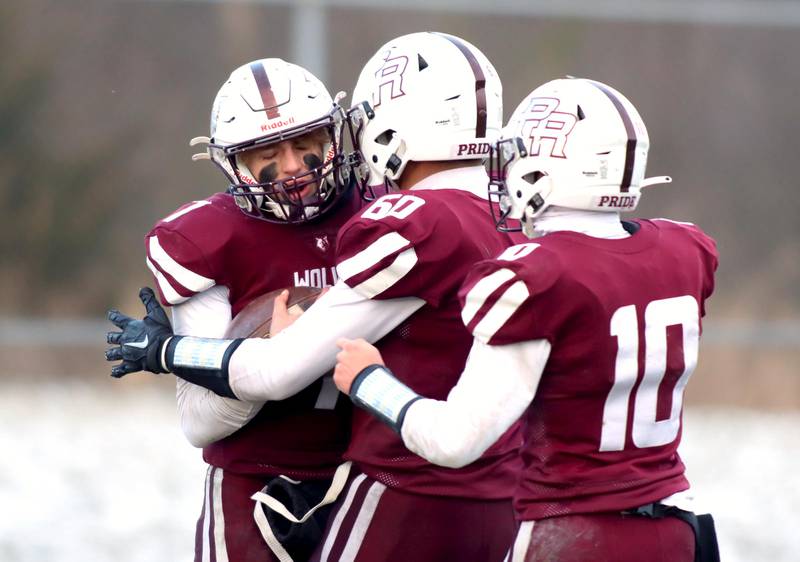Prairie Ridge’s Tyler Vasey, left, is greeted in the end zone by Fernando Rodriguez, center, and Jack Finn  in Class 6A football playoff semifinal action at Crystal Lake on Saturday.