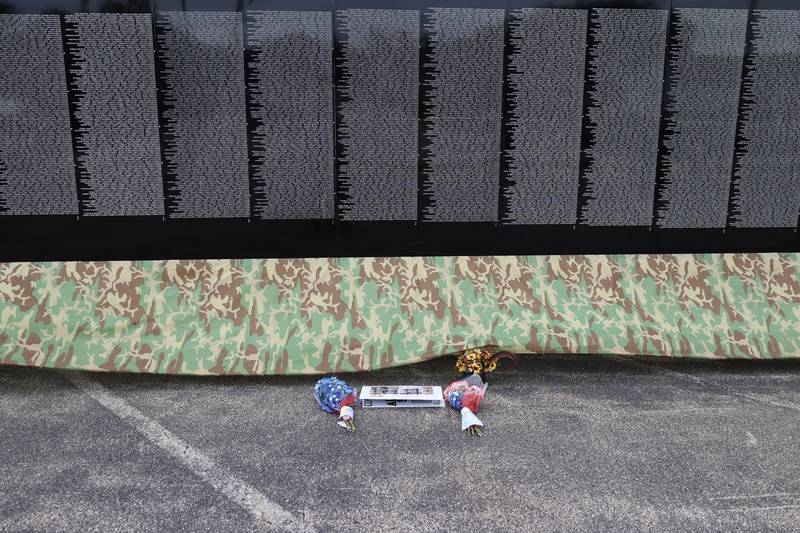 Flowers and photos sit along the Vietnam Moving Wall on Saturday, July 1st, 2023, in Manhattan.