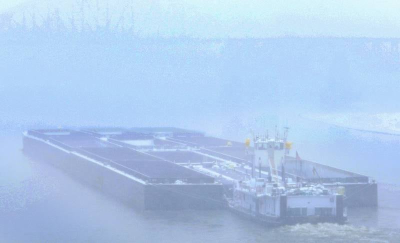 An empty barge travels upstream through the snow on Monday, Dec. 1, 2025 near La Salle.